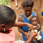 A community health worker measures arm circumference in Bonsasso, Ghana.