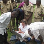 Curious Malawian policemen watch Donna, Winstone and Patrick download seismic data.